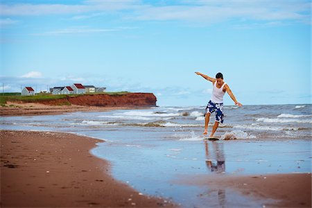 Young Man Riding Skimboard near Shoreline, PEI, Canada Fotografie stock - Premium Royalty-Free, Codice: 600-05641656