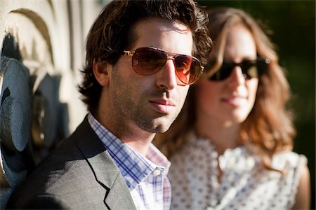 Close-up Portrait of Young Couple Standing in front of Stone Sculptures in Park, Ontario, Canada Stock Photo - Premium Royalty-Free, Code: 600-05786170