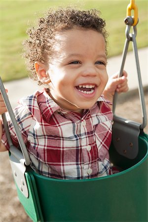 Close-up Portrait of Young Boy in Swing at Playground Foto de stock - Royalty Free Premium, Número: 600-05786425