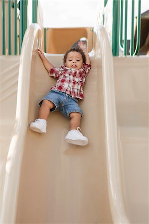 deslizarse - Young Boy Sliding Down Slide at Playground Foto de stock - Sin royalties Premium, Código: 600-05786426