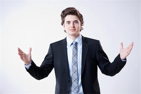 portrait young man white background - Portrait of Young Businessman using Hand Gesture Stock Photo - Premium Royalty-Free, Code: 600-05973097