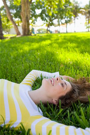 portrait of a beautiful young woman smile - Woman Lying on Grass, Miami Beach, Florida, USA Stock Photo - Premium Royalty-Free, Code: 600-06125459