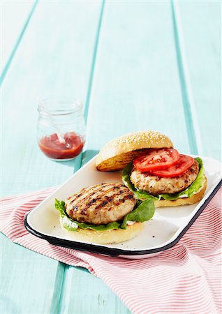 food on colored background - Barbecued Turkey Burgers with Lettuce and Tomotoes Stock Photo - Premium Royalty-Free, Code: 600-06397682