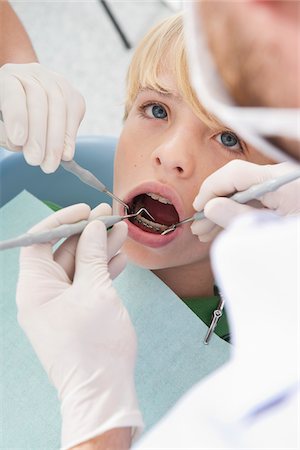 dentist boy blonde - Dentist and Hygienist checking Boy's Teeth during Appointment, Germany Stock Photo - Premium Royalty-Free, Code: 600-06438917