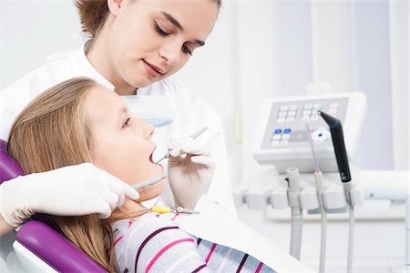 dental bib - Dentist Checking Girl's Teeth during Appointment, Germany Stock Photo - Premium Royalty-Free, Code: 600-06438936