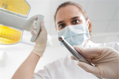 female dentist with gloves and mask - Close-up of Dental Drill held by Dentist in Dental Office, Germany Foto de stock - Sin royalties Premium, Código: 600-06438941