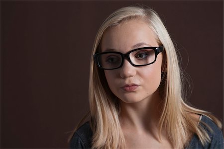 rubio - Close-up Portrait of Blond, Teenage Girl, wearing Eyeglasses and Looking to the Side, Studio Shot on Black Background Foto de stock - Sin royalties Premium, Código: 600-06438955