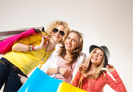 Portrait of Three, Cool Teenage Girls, Looking at Camera Smiling, Holding Shopping Bags, Diagonal Studio Shot on White Background Photographie de stock - Premium Libres de Droits, Code: 600-06438971