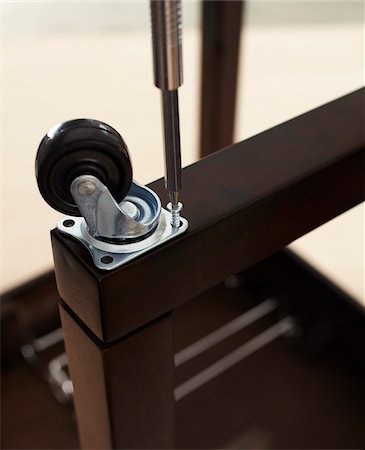 piede del tavolo - Close-up of Screwdriver Attaching Caster Wheel to Table Fotografie stock - Premium Royalty-Free, Codice: 600-06431325