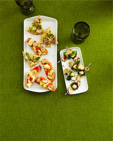 skewers - Overhead View of Mushroom Appetizers on Trays with Drinking Glasses on Green Background in Studio Stock Photo - Premium Royalty-Free, Code: 600-06431329