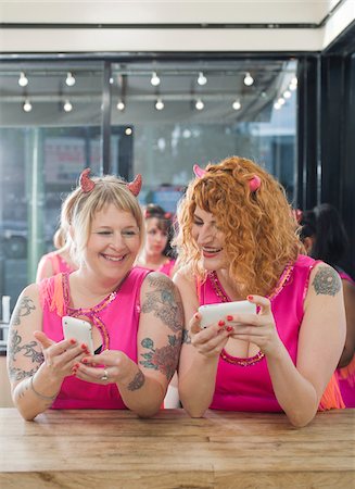 Women Wearing Devil Horns and Costumes Using Cellular Telephones, Oakland, Alameda County, California, USA Foto de stock - Sin royalties Premium, Código: 600-06431370