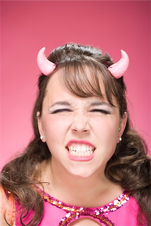 Portrait of Woman Wearing Devil Horns and Scowling Stock Photo - Premium Royalty-Free, Code: 600-06431387