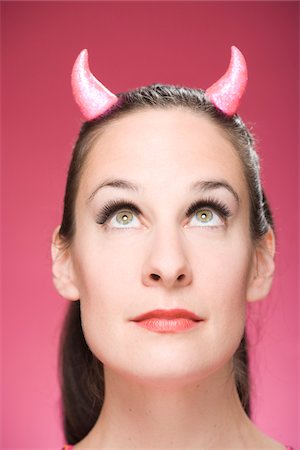 simsearch:600-06431428,k - Portrait of Woman Wearing Devil Horns Looking Up Stock Photo - Premium Royalty-Free, Code: 600-06431380