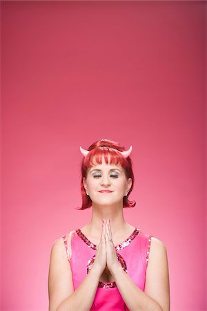 simsearch:600-06431399,k - Portrait of Woman Wearing Devil Horns Praying Foto de stock - Sin royalties Premium, Código: 600-06431414