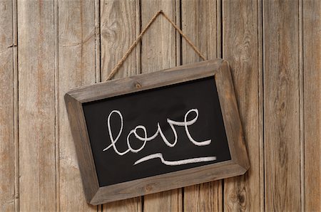 Love Written in Cursive on Chalkboard and Hanging on Wooden Wall Stock Photo - Premium Royalty-Free, Code: 600-06451953