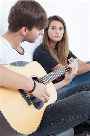 simsearch:600-06701796,k - Young Man Playing Acoustic Guitar to Teenage Girl Photographie de stock - Premium Libres de Droits, Code: 600-06465373