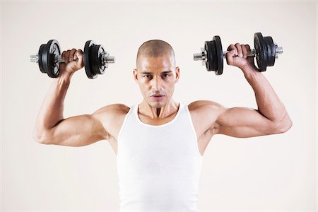 pumping - Man Wearing Work Out Clothes and Lifting Weights in Studio with White Background Stock Photo - Premium Royalty-Free, Code: 600-06485939