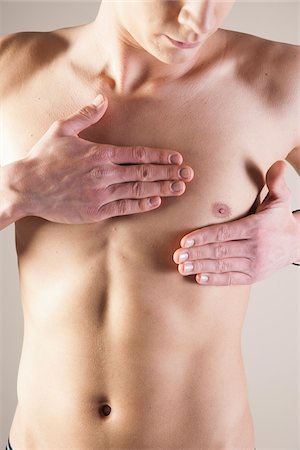 stomaco - Close-up of Young Man from the Waist up Touching Chest in Studio Fotografie stock - Premium Royalty-Free, Codice: 600-06486007