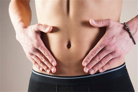 Close-up of Young Man in Underwear Touching Stomach in Studio Foto de stock - Sin royalties Premium, Código: 600-06486010