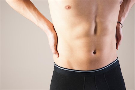 Close-up of Young Man in Boxer Briefs Touching Stomach in Studio