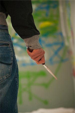 Close-up of Young Man Holding Knife with Graffiti in Background, Mannheim, Baden-Wurttemberg, Germany Photographie de stock - Premium Libres de Droits, Code: 600-06486013