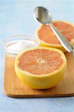 Close-up of Grapefruit cut in half with Bowl of Sugar and Spoon on Cutting Board, Studio Shot Photographie de stock - Premium Libres de Droits, Code: 600-06486041