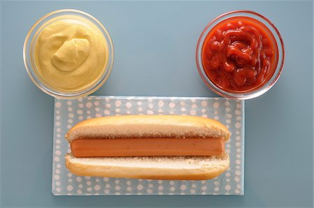 perro caliente - Overhead View of Hot Dog with Bowls of Ketchup and Mayonnaise, Studio Shot Foto de stock - Sin royalties Premium, Código: 600-06486042