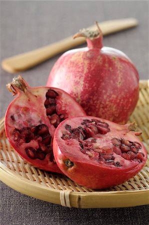 simsearch:600-06486058,k - Close-up of Pomegranates on Tray, One cut in half on Grey Background, Studio Shot Photographie de stock - Premium Libres de Droits, Code: 600-06486057