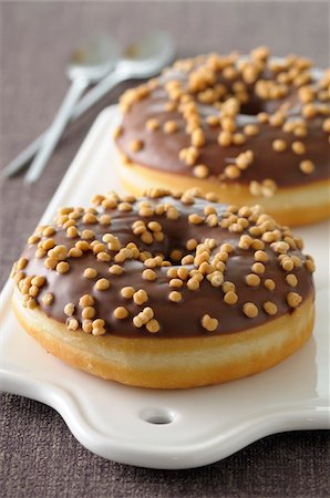 Close-up of Caramel Donuts on Cutting Board on Grey Background, Studio Shot Stockbilder - Premium RF Lizenzfrei, Bildnummer: 600-06486051