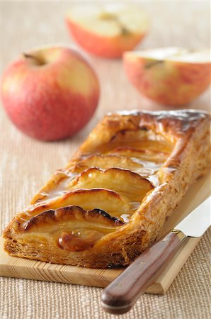 Close-up of Apple Tart with Knife on Cutting Board with Apples in background, Studio Shot Stock Photo - Premium Royalty-Free, Code: 600-06486066