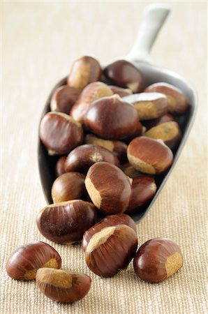 sweet chestnuts - Close-up of Chestnuts Spilling from Scoop on Beige Background, Studio Shot Stock Photo - Premium Royalty-Free, Code: 600-06486068