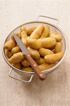 potato - Overhead View of Potatoes in Colander with Knife on Beige Background, Studio Shot Stock Photo - Premium Royalty-Free, Code: 600-06486074