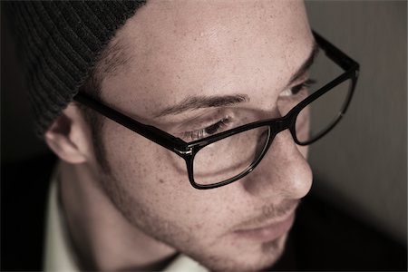 Close-up, High Angle View of Young Man wearing Woolen Hat and Eyeglasses, Studio Shot Stock Photo - Premium Royalty-Free, Code: 600-06486246