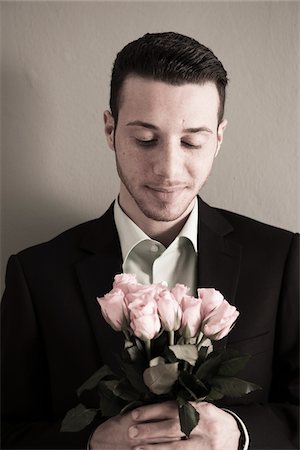 flower shirt - Portrait of Young Man holding and Looking Down at Bouquet of Pink Roses, Studio Shot Foto de stock - Sin royalties Premium, Código: 600-06486240