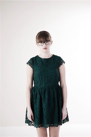 Portrait of Young Woman wearing Green, Lace Dress and Horn-rimmed Eyeglasses, Looking at Camera, Studio Shot on White Background Stockbilder - Premium RF Lizenzfrei, Bildnummer: 600-06486275