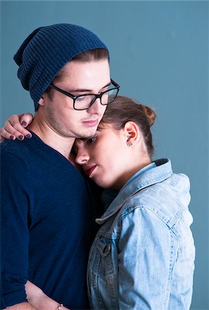 Portrait of Young Couple Embracing, Studio Shot on Blue Background Stock Photo - Premium Royalty-Free, Code: 600-06486270