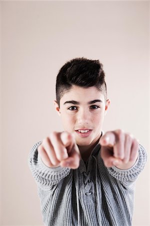 enfoque en el fondo - Portrait of Boy Pointing at Camera in Studio Foto de stock - Sin royalties Premium, Código: 600-06486396