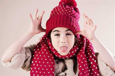 Portrait of Girl making faces wearing Hat and Scarf in Studio Stock Photo - Premium Royalty-Free, Code: 600-06486406