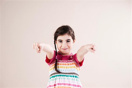 smiling people portrait white background - Portrait of Girl Pointing at Camera in Studio Foto de stock - Sin royalties Premium, Código: 600-06486416