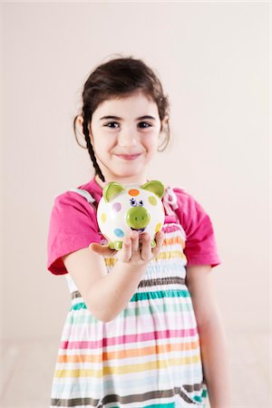 Portrait of Girl holding Piggy Bank in Studio Foto de stock - Sin royalties Premium, Código: 600-06486429