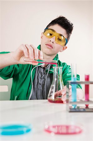 erlenmeyer flask and beaker - Boy wearing Safety Glasses Pouring Liquid from Test Tube into Beaker, Mannheim, Baden-Wurttemberg, Germany Photographie de stock - Premium Libres de Droits, Code: 600-06486448