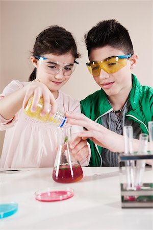 expérience (science) - Boy and Girl wearing Safety Glasses Pouring substance into Beaker, Mannheim, Baden-Wurttemberg, Germany Photographie de stock - Premium Libres de Droits, Code: 600-06486451