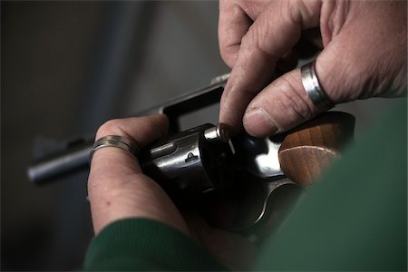 danger - Close-up of Man Loading Bullets into Gun, Mannheim, Baden-Wurttemberg, Germany Photographie de stock - Premium Libres de Droits, Code: 600-06486465