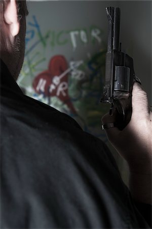 revolver - Close-up of Man holding Gun with Graffiti in Background, Mannheim, Baden-Wurttemberg, Germany Photographie de stock - Premium Libres de Droits, Code: 600-06486479