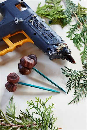 Glue gun on a craft table with cedar branches and chestnuts glued as a holiday craft Stock Photo - Premium Royalty-Free, Code: 600-06531995