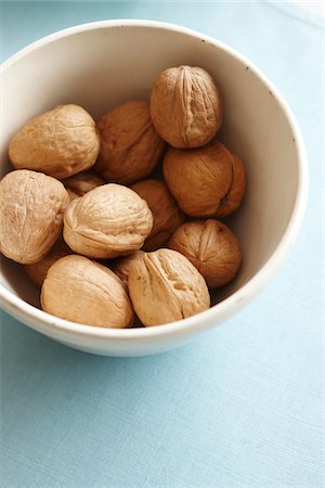 whole walnuts in the shell in a bowl on a blue fabric Photographie de stock - Premium Libres de Droits, Code: 600-06532015