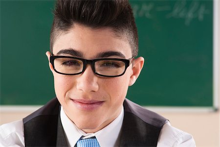 escolares - Close-up Portrait of Boy in front of Chalkboard in Classroom Foto de stock - Sin royalties Premium, Código: 600-06543522