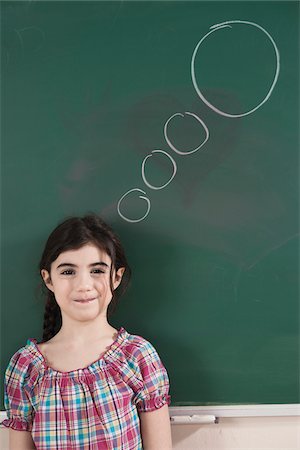 sólo niños - Girl in Front of Chalkboard with Thought Bubble in Classroom Foto de stock - Sin royalties Premium, Código: 600-06543534