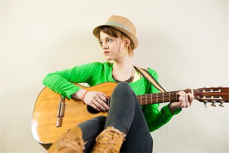 Portrait of Teenage Girl Wearing Hat and Playing Acoustic Guitar, Studio Shot on White Background Stock Photo - Premium Royalty-Free, Code: 600-06553413