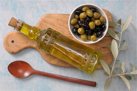 simsearch:600-07067667,k - Overhead View of Bowl of Olives and Bottle of Olive Oil on Cutting Board with Wooden Spoon Stock Photo - Premium Royalty-Free, Code: 600-06553474